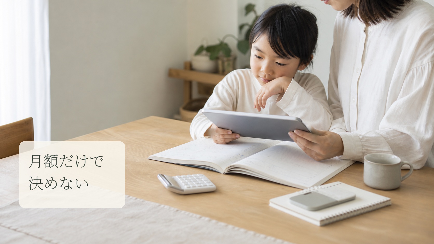 保護者と小学生が紙教材とタブレットを見ながら家庭学習費を確認する様子