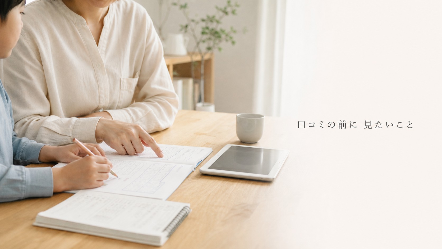 紙教材とタブレットを前に学習計画を確認する小学生と保護者