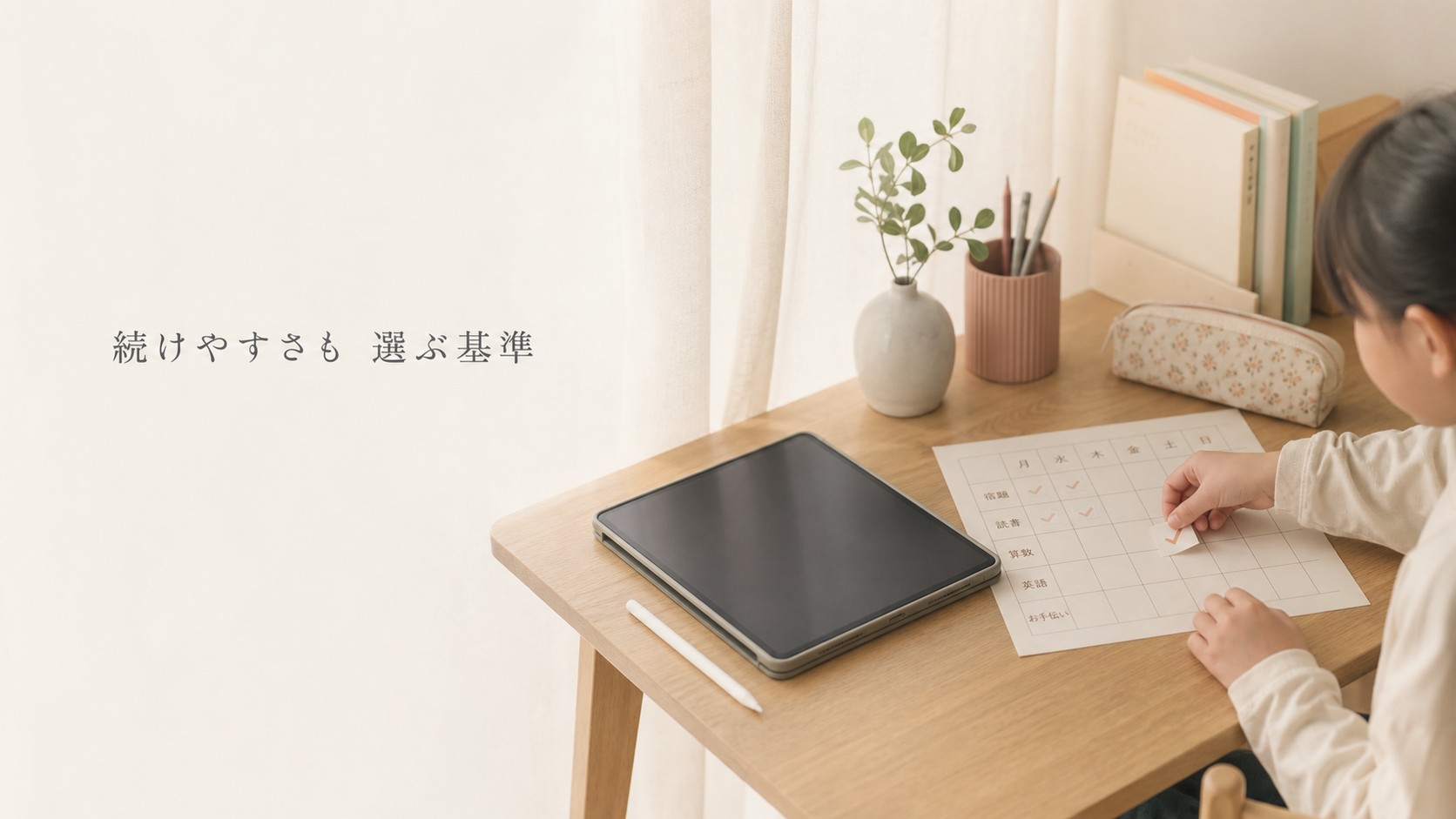 タブレット学習と一週間の習慣表を確認する小学生